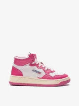 Championes de caña media Autry modelo 01 Mid, confeccionados en cuero bicolor blanco y fucsia. Presentan diseño perforado en la puntera, cierre con cordones y suela de goma con efecto envejecido.