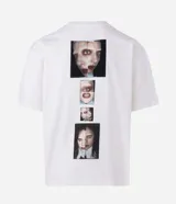 Remera blanca de algodón con modelado boxy, cuello redondo y manga corta. Presenta un estampado central en la parte delantera que forma una cruz con la palabra "MAYHEM" en el centro.