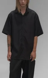 Camisa de manga corta con calce oversize, confeccionada en tejido de lyocell, con cuello clásico y cierre frontal de botones.