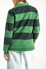 Sweater de punto con diseño de rayas horizontales anchas en tonos verde oscuro y verde claro, con cuello tipo polo y cierre frontal parcial. Presenta mangas largas con puños elásticos y un pequeño bordado en la parte inferior.