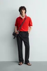 Polo de manga larga color rojo, confeccionado en tejido de algodón con estructura piqué, cuello solapa y cierre frontal de botonadura. Presenta aberturas laterales en el bajo.