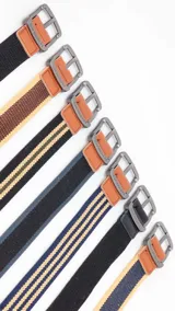 Cinturón casual confeccionado en tela canvas con diseño bicolor o a rayas. Cuenta con hebilla metálica de acabado envejecido, detalles en cuero sintético en los extremos y ojales reforzados.