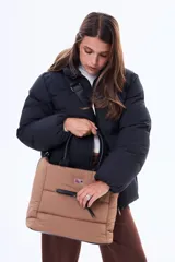 Bolso tipo tote color negro, con diseño acolchado y manijas fijas. Cuenta con una correa larga ajustable y desmontable, cierre principal superior y un bolsillo frontal con cierre.