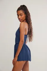 Vestido corto deportivo negro con efecto smock en el torso, tirantes finos blancos y falda de vuelo suave.