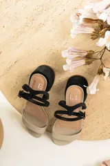 Sandalias de cuero color suela con taco cuadrado bajo y tira ajustable con hebilla en el tobillo.