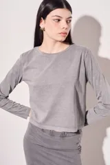 Remera color marrón de algodón peinado, corte oversize, cuello redondo y manga larga.