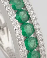 Caravanas de plata 925 con diseño rectangular, decoradas con una hilera central de piedras verdes y bordes con circonias brillantes. Cuentan con cierre tipo omega.