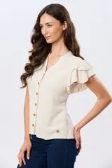 Camisa de lino y viscosa color beige, con cuello mao, escote en V y botones frontales de madera. Presenta mangas cortas con volados delicados.