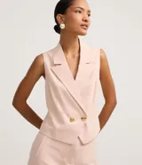 Chaleco femenino de sastrería color rosa pálido, con cuello blazer, cruce delantero con botones dorados y corte estructurado.