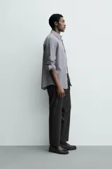 Pantalón de vestir regular fit color negro, confeccionado en tejido con mezcla de lana y elasticidad. Cuenta con cintura elástica, bolsillos frontales, bolsillos traseros de vivo con botón, y cierre frontal con cremallera y botón.
