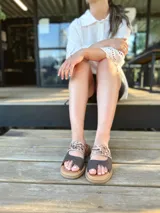 Sandalias bajas de cuero con dos tiras, una de cuero liso color gris y otra con estampado animal print.