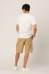 Bermuda color beige de gabardina con licra y corte a la rodilla. Cuenta con bolsillos laterales tipo cargo con solapa y bolsillos delanteros y traseros.