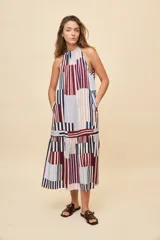 Vestido largo de silueta amplia y caída fluida, con escote halter fruncido y falda con recorte. Presenta diseño geométrico multicolor a rayas en tonos bordó, azul, celeste y beige.