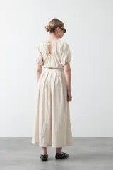 Top negro de manga corta con escote redondo y frunces en la costura de la sisa, creando un efecto de manga abullonada. El tejido parece ligero y con textura.