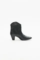 Bota corta de cuero negro con taco medio y punta fina. Presenta recortes grabados en el mismo material en el cuerpo de la bota.