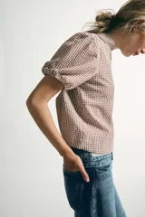 Camisa de manga corta con estampado de cuadros vichy, cuello subido y detalle de abertura en la espalda con lazada del mismo tejido.
