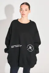 Buzo oversize negro de frisa con cuello redondo, hombros caídos, bolsillos delanteros y estampa serigráfica en delantero y espalda.