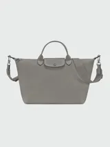 Bolso de mano Longchamp modelo Le Pliage Xtra L, color negro, confeccionado en cuero vacuno. Presenta un diseño estructurado con solapa frontal con botón a presión, doble asa superior y correa de hombro ajustable y extraíble con logo grabado.