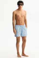 Short de baño celeste con estampado tropical en tonos claros, cintura elástica con cordón de ajuste y bolsillos laterales.