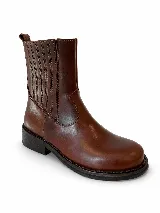 Bota de caña media confeccionada en cuero vacuno con efecto desgastado. Presenta elásticos laterales para un calce cómodo, taco de madera y suela de caucho.