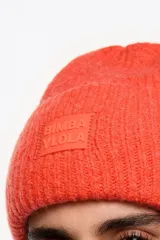 Gorro tipo beanie de punto acanalado en color negro, con vuelta y parche frontal con el logo de la marca Bimba y Lola.