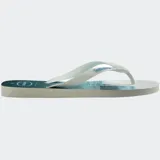 Ojotas Havaianas con base blanca y celeste con estampado de olas. Tiras blancas con diseño en relieve y logo de la marca.