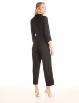 Enterito negro de la marca Sharagano, con escote en V y solapa. Presenta cierre frontal, bolsillos aplicados en la parte delantera, mangas largas con presilla y botón para regular el largo, y lazo de ajuste en la cintura.