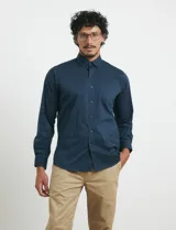 Camisa de manga larga con cuello button-down y bolsillo frontal. Confeccionada en tejido con elastano para mayor comodidad y libertad de movimiento.