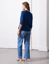 Blusa azul con cuello a la base y escote en V. Tiene bolsillos con cierre metálico.