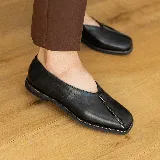 Zapato bajo de cuero negro con punta cuadrada y detalle de cierre en la capellada.