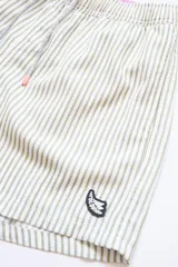 Short de baño a rayas verticales color beige y blanco, con cintura elástica ajustable con cordón, bolsillos laterales y trasero con cierre, y logo bordado en la pierna.