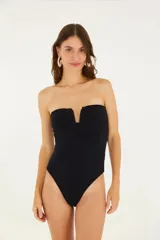 Malla enteriza negra sin tirantes, con diseño strapless y escote en V central. Presenta una textura floral sutil en toda la prenda y corte de pierna alto.