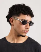 Lentes de sol con marco plateado y lentes ovalados negros.