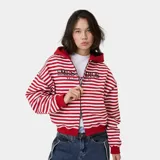 Campera con capucha de felpa de algodón, con diseño a rayas horizontales rojas y blancas, cierre frontal con cremallera bidireccional y bolsillos tipo canguro. Presenta grandes letras bordadas con el texto "EMESTUDIOS Madrid, 5135" en el pecho.