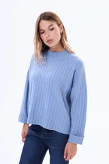 Buzo tejido de punto acanalado en color bordó, con cuello alto y mangas largas anchas con puños ajustados.