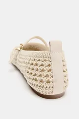 Zapatos planos tipo bailarina de color beige, confeccionados en tejido con efecto trenzado. Presentan una tira en el empeine con hebilla metálica dorada, tirador trasero y suela plana.