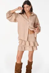 Minifalda amarilla confeccionada en lino italiano, de corte en A, con diseño de doble volado escalonado y detalles de terminación con bordado calado.