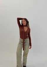 Body marrón de tejido acanalado, mangas largas, escote en V y corbatín tipo choker.