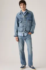 Pantalón de jean corte regular, con diseño clásico de cinco bolsillos, cierre de botón y cremallera, en tono azul medio con acabado desgastado.