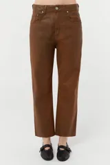 Jean de denim 100% algodón color marrón con coating engomado que le da un efecto cuero. Calce Mom con cintura alta y pierna recta.