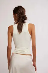 Musculosa de tejido texturado sin costuras, color negro, con escote redondo pronunciado y tiras anchas. Presenta un diseño ajustado y corto al cuerpo.