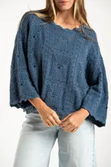 Sweater de tejido de punto calado color marrón, con diseño oversize, cuello redondo y mangas tres cuartos.