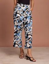 Pantalón fluido de corte recto y largo midi, con estampado abstracto en tonos azul, negro y crema. Presenta cintura elastizada en la parte posterior y bolsillos laterales delanteros.