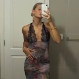 Vestido midi de microtul con estampado floral abstracto en tonos oscuros y detalle de encaje negro en el escote halter. Posee espalda regulable con breteles.