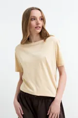 Remera de manga corta color beige, con cuello redondo y estampa frontal con la frase "It's always summer somewhere".