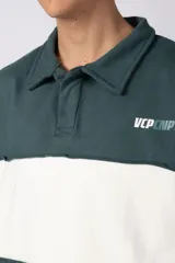 Buzo tipo polo de calce relajado con diseño de bloques de color en tonos marrón y blanco. Presenta cuello polo, cierre frontal parcial y logo estampado en el pecho. Confeccionado en tejido pesado con estructura.