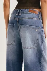 Jean slouchy de tiro alto color crudo, con silueta relajada tipo barrel que se afina hacia los tobillos.