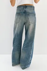 Jean de corte recto y tiro regular, confeccionado en denim de algodón en tono azul medio con efecto desteñido y diseño de cinco bolsillos.