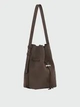 Cartera tipo bucket bag de hombro Longchamp modelo Le Roseau Velvety M, confeccionada en cuero marrón con textura de gamuza. Cuenta con correa de hombro ajustable y detalle de cierre de barrita metálica con el distintivo de la marca.