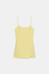 Mono corto amarillo pastel con escote redondo, tirantes finos ajustables y abertura frontal con solapa. Presenta cierre lateral oculto.
